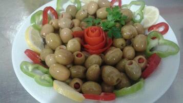 A plate of olives, red bell peppers, and lemon slices.