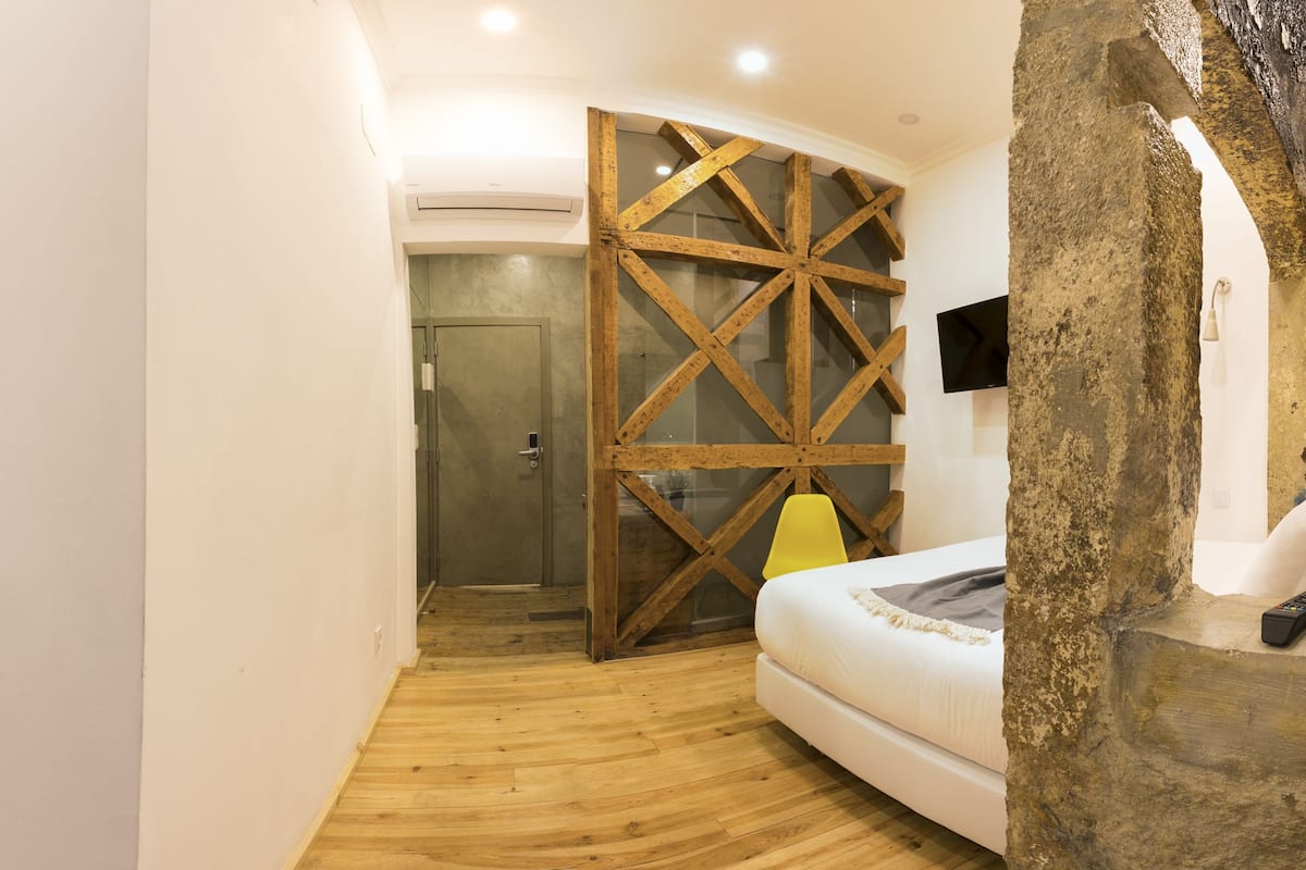 Un dormitorio con literas, un armario de madera, una ducha y un televisor.