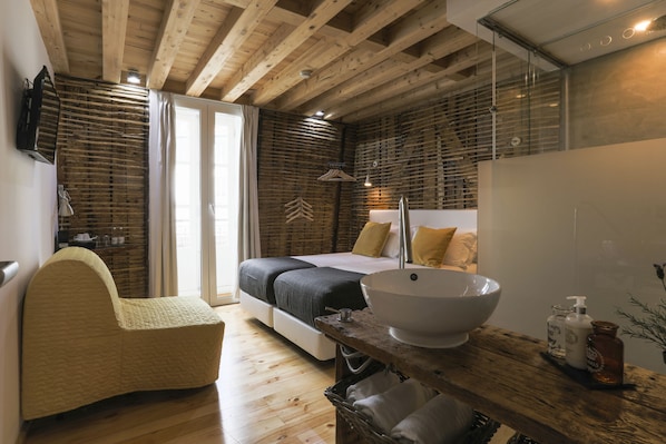 A bedroom with a bed, bedside table, and a large bowl sink.