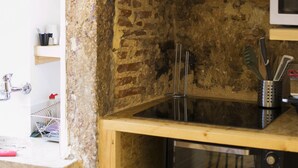 Una cocina con microondas, tostadora y estante de madera.