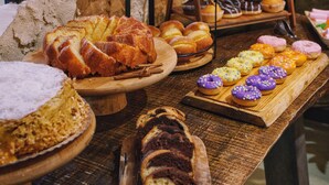 Una mesa de madera con varias preparaciones horneadas, como pan, pasteles y un pastel.