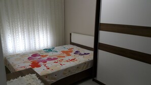 A bedroom with a bed, white curtains, and a wooden headboard. - Pembe Villa Alacati (Cesme)