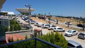 A parking lot with multiple cars, a building with a sign reading "Oasis Aquapark", and a view of the surrounding area including a road and some greenery.