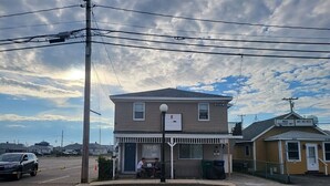A two-story building with a porch and a small attached structure. - 12 Ashworth Ave (Hampton)
