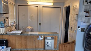 A reception desk with a key box, a push button, and a wall-mounted security camera. - 12 Ashworth Ave (Hampton)