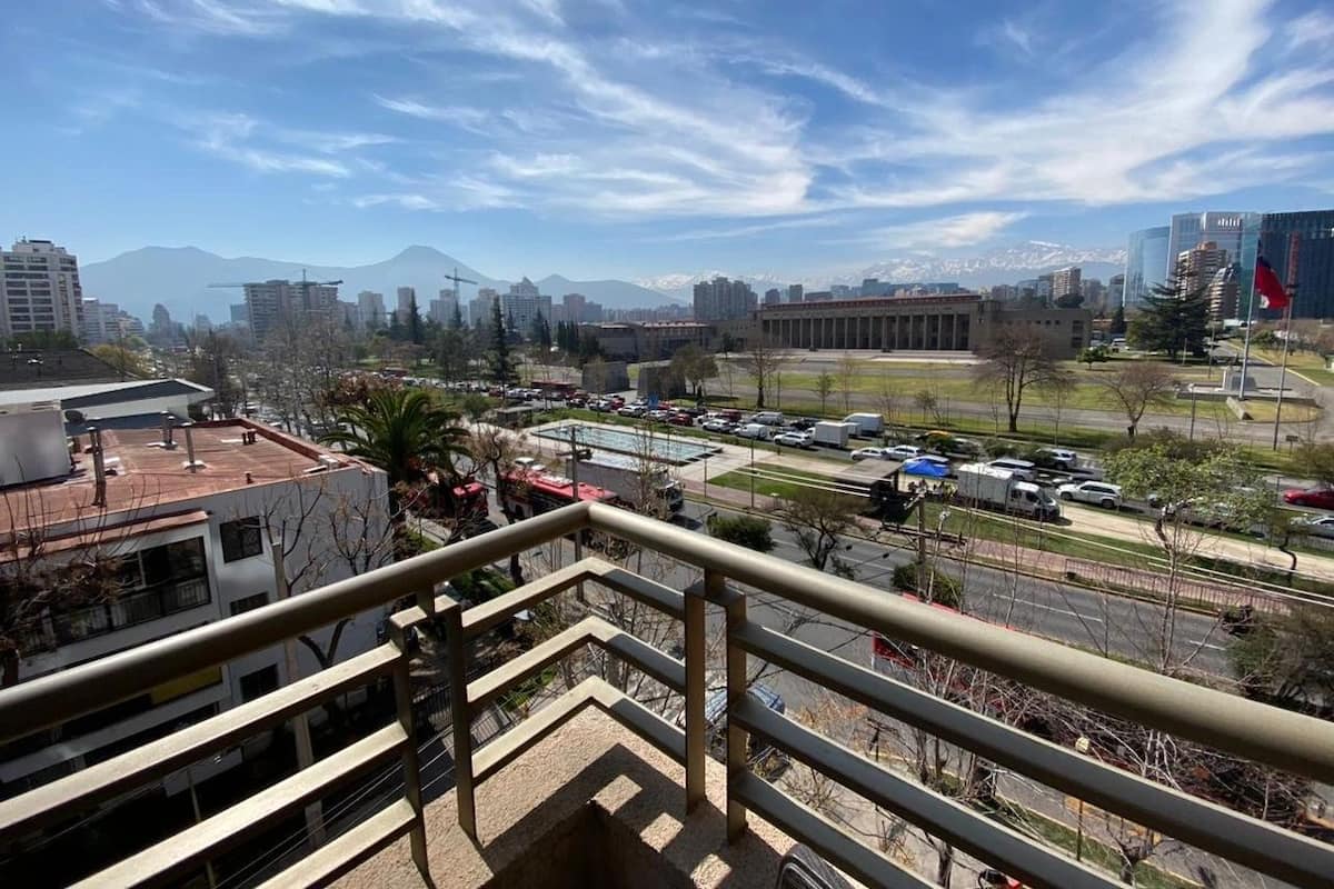 Un paisaje urbano con edificios, carreteras y montañas al fondo.