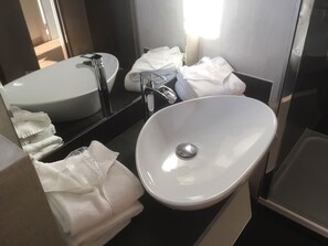 A modern bathroom with a white sink, a large mirror, and neatly folded towels. - Hôtel Le Fangassier (Saintes-Maries-de-la-Mer)