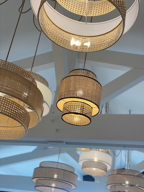 A ceiling with multiple hanging pendant lights with a woven design.