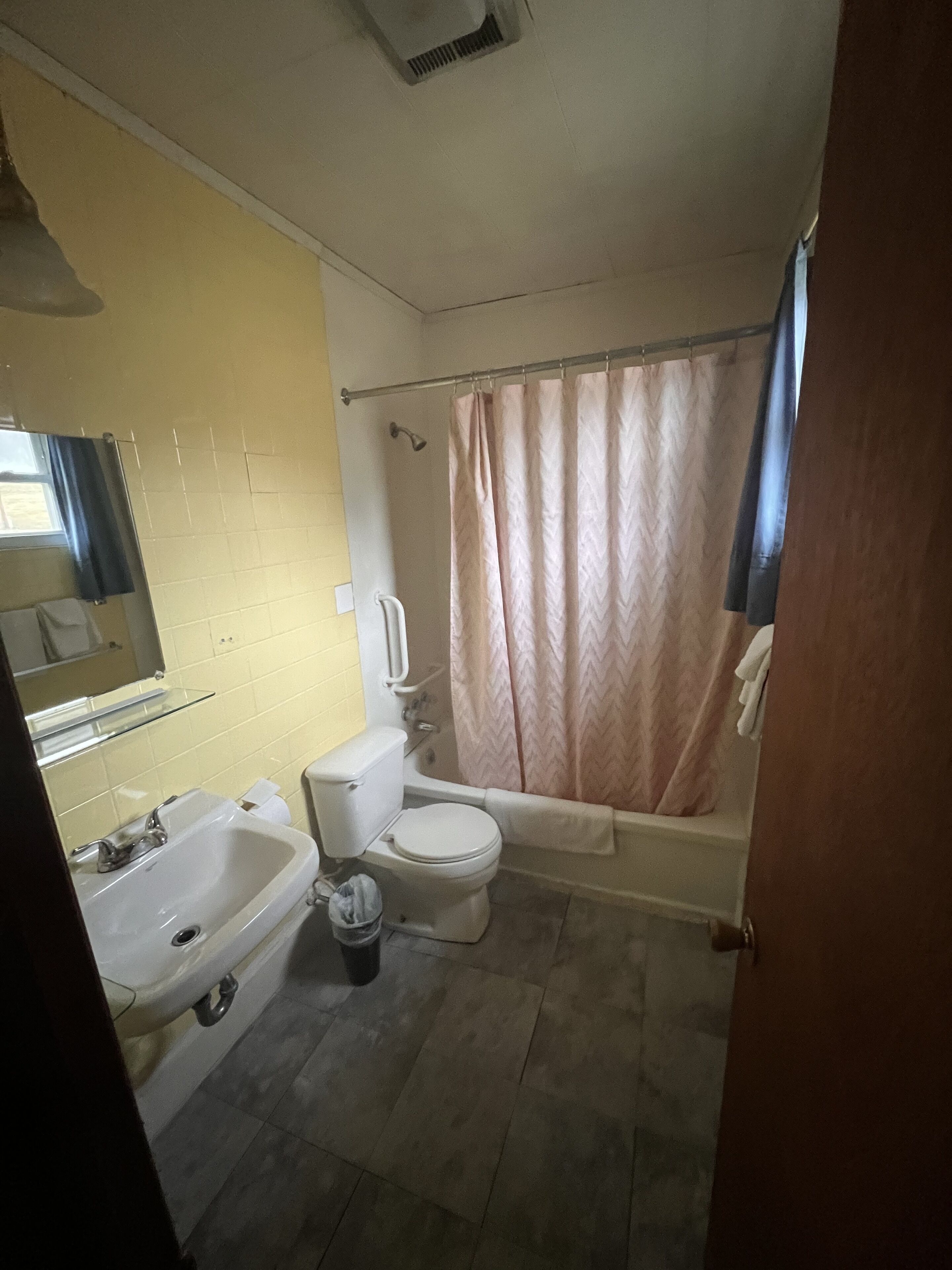 A bathroom with a toilet, sink, and bathtub.