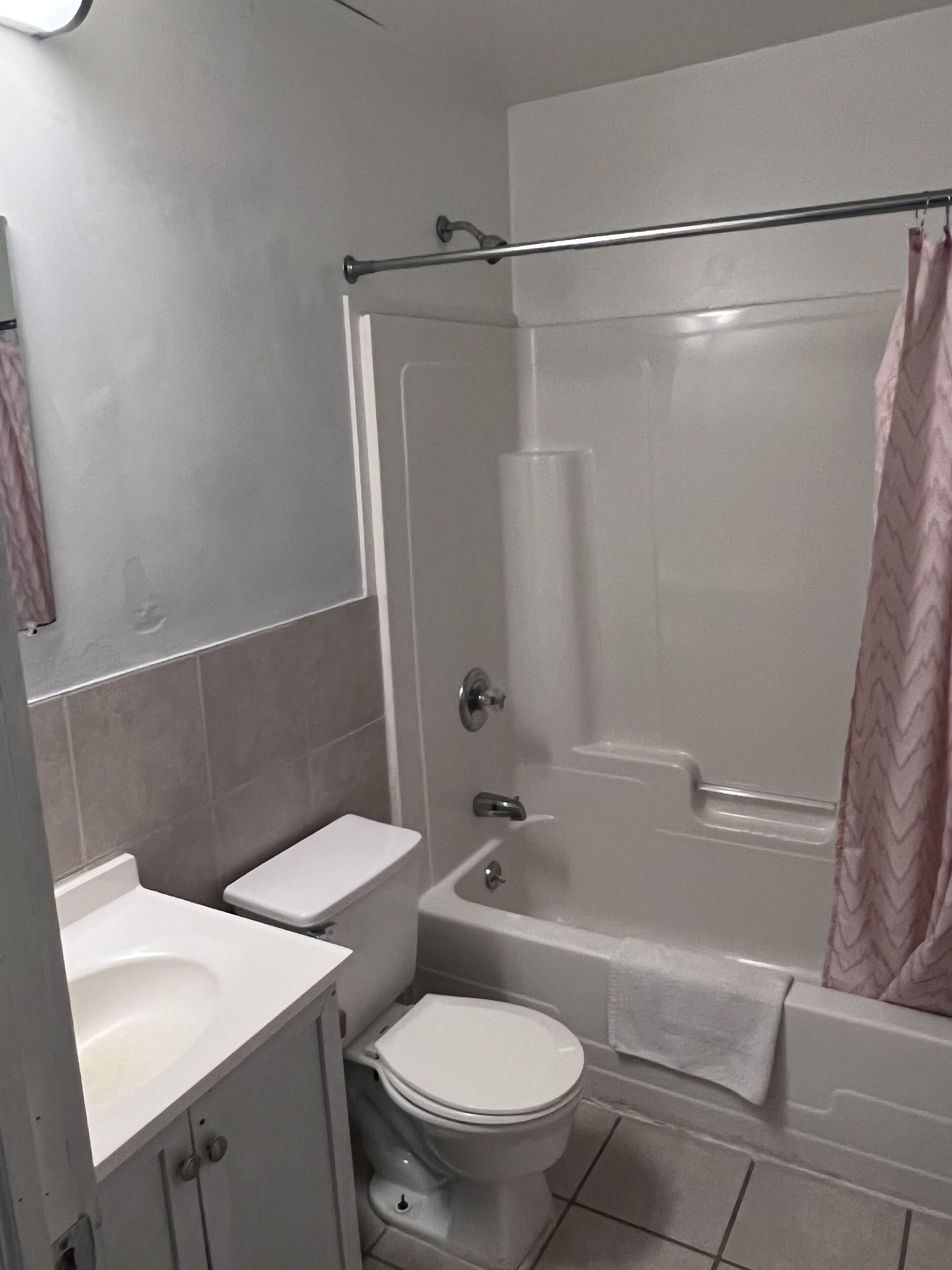 A bathroom with a toilet, sink, and bathtub.