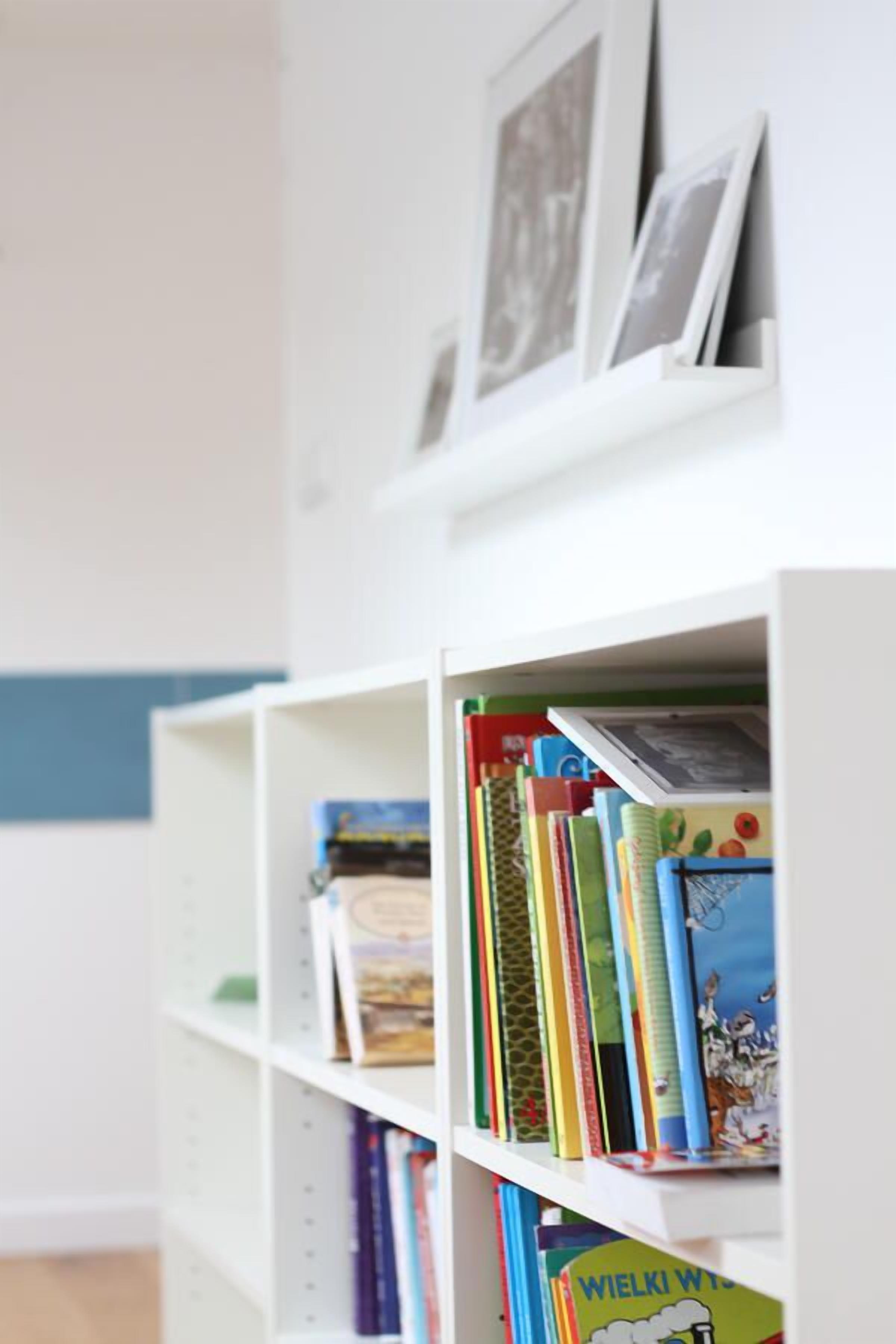 A bookshelf with various books and a framed picture.