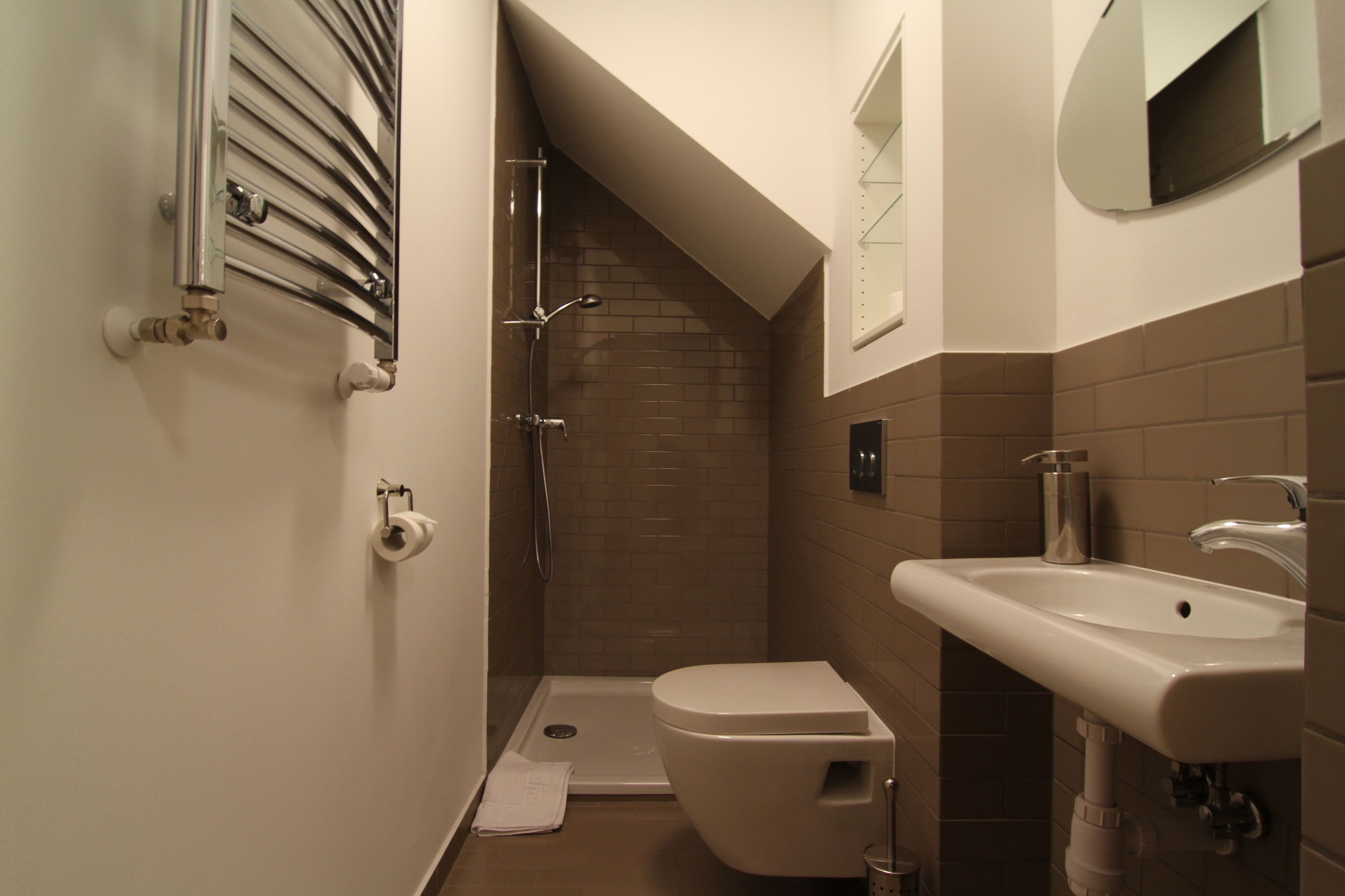 A small bathroom with a shower, toilet, and sink.