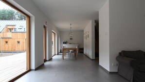 Um interior moderno com área de jantar, cozinha e uma janela grande.