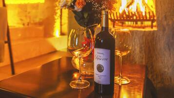 Una botella de vino sobre una mesa con un fuego al fondo.