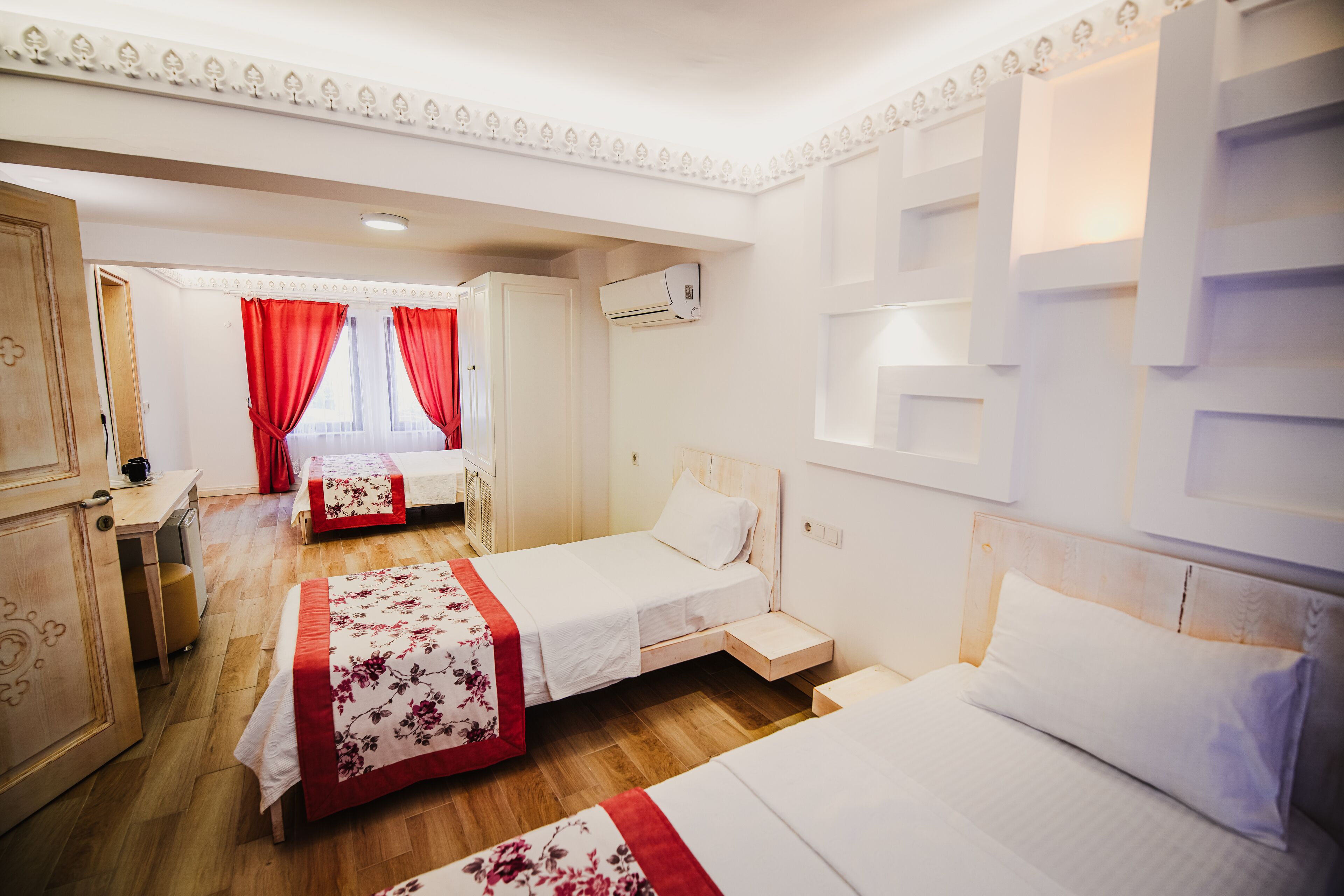Ein Hotelzimmer mit zwei Betten, einem Schreibtisch und einem Kleiderschrank.