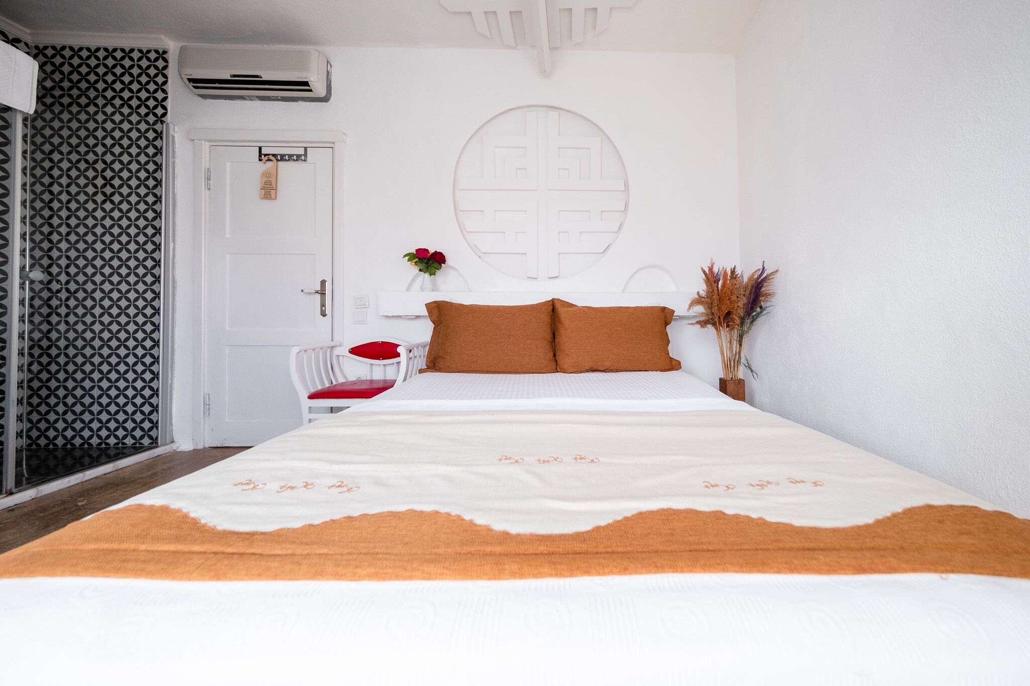 A neatly arranged bedroom with a bed, a chair, and a door.