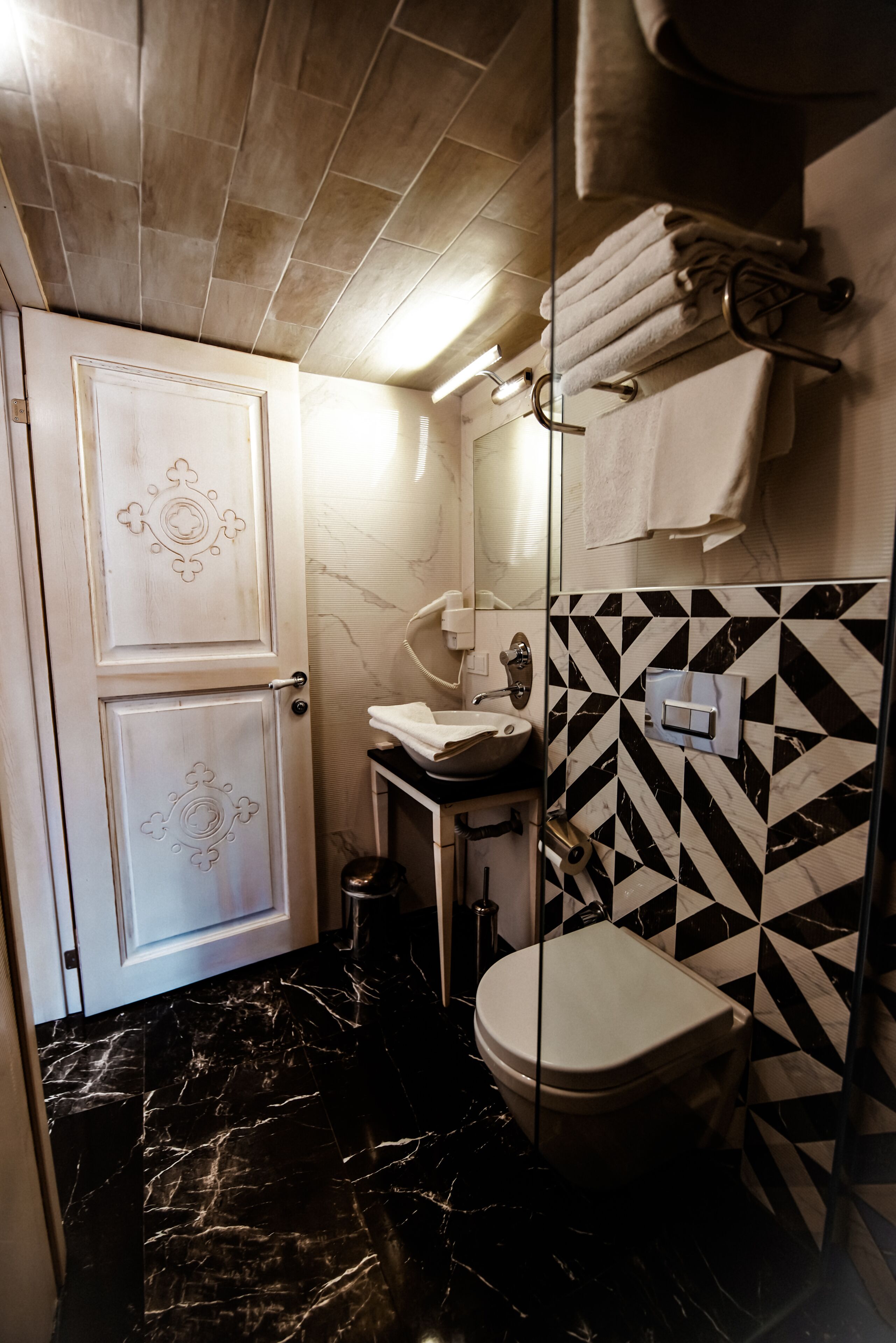 Un bany amb terra de marbre, un vàter, un lavabo i un mirall.