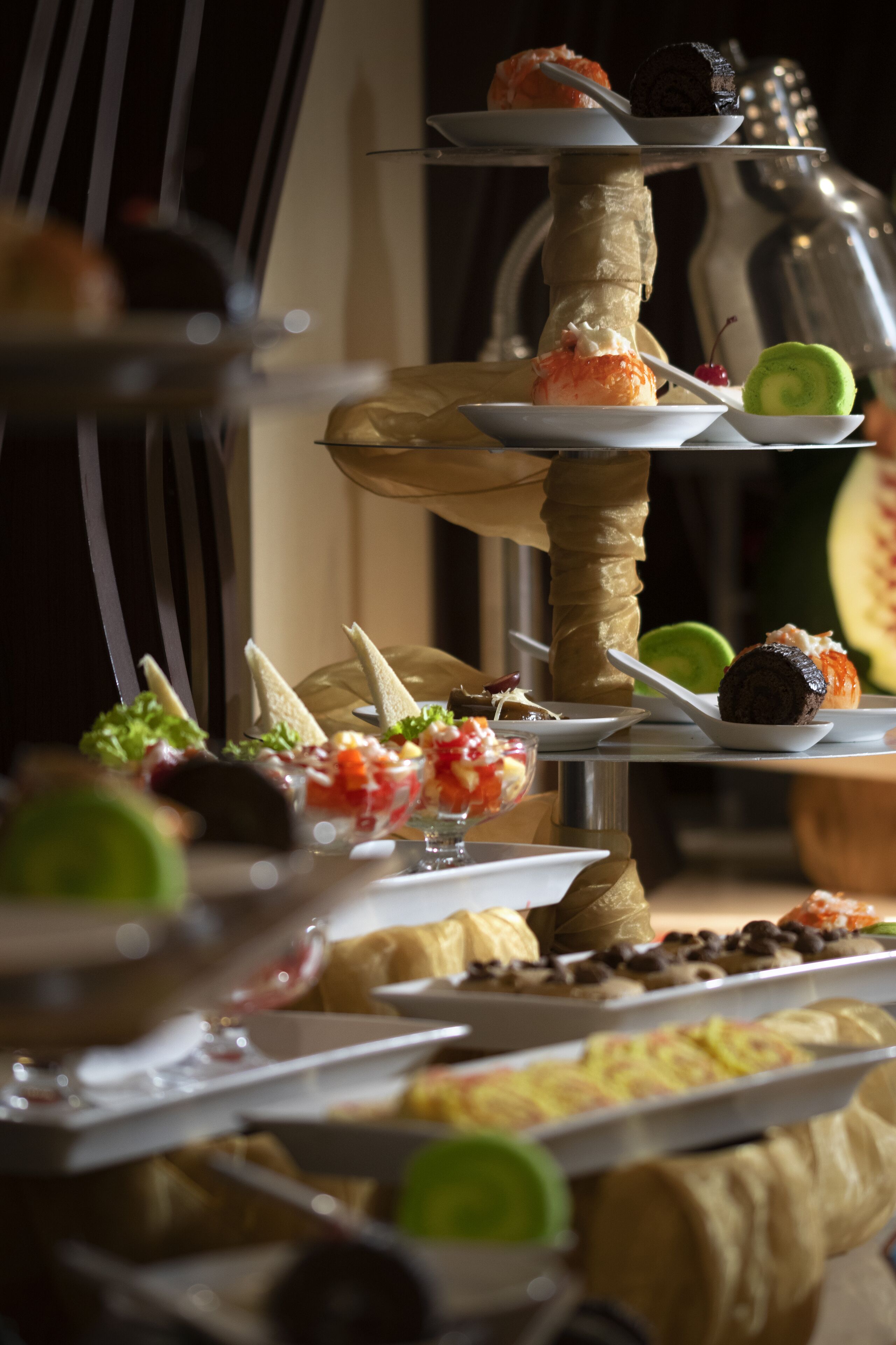 A multi-tiered dessert display with various pastries and fruits.
