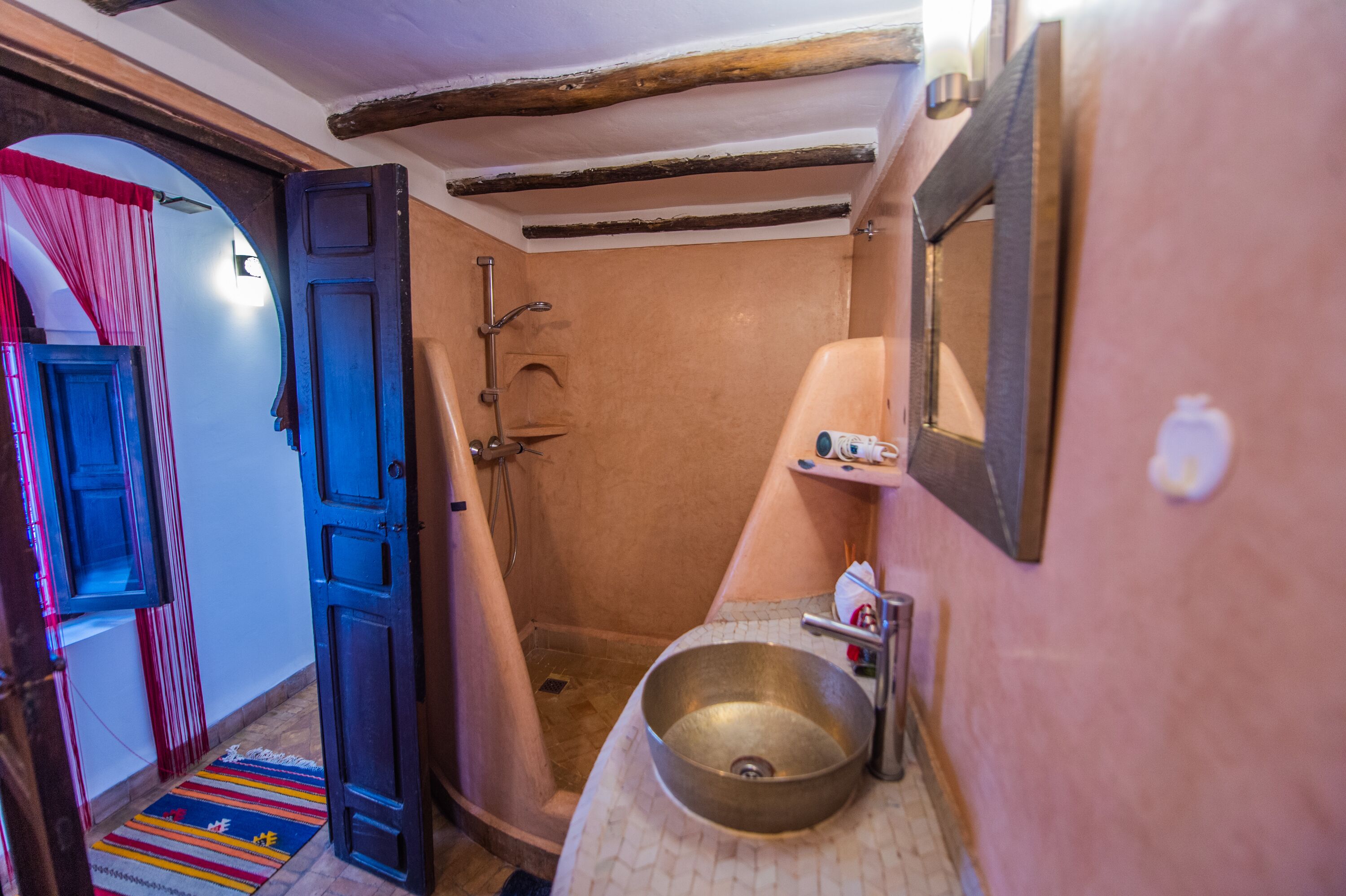 A bathroom with a shower, a sink, and a mirror.