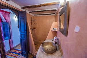 Un baño con ducha, lavamanos y espejo.