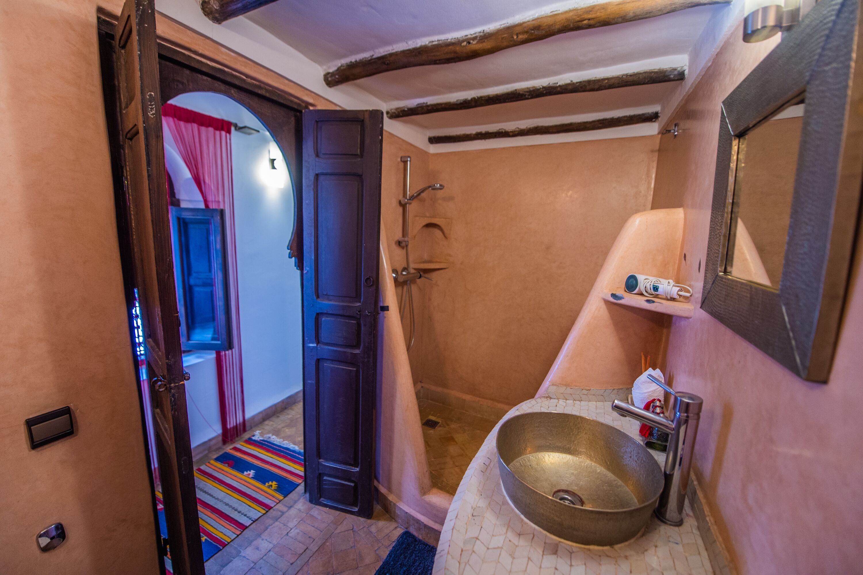 Un baño con ducha, lavabo y espejo.
