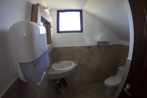Un baño con inodoro, lavamanos y ventana.