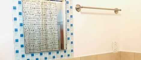 A bathroom with a sink, mirror, and blue cabinets.