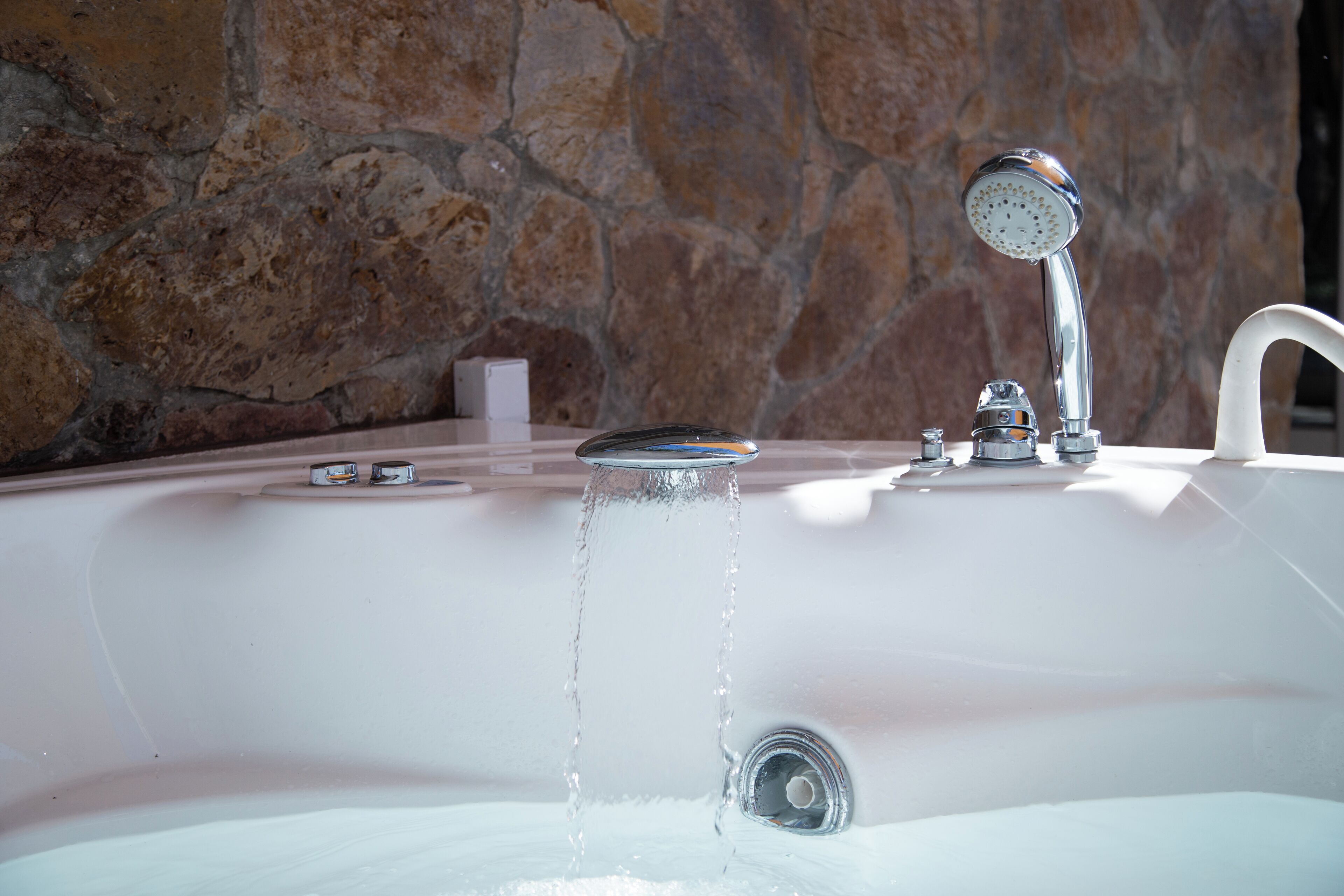 Une baignoire remplie d’eau, un robinet et un porte-savon.