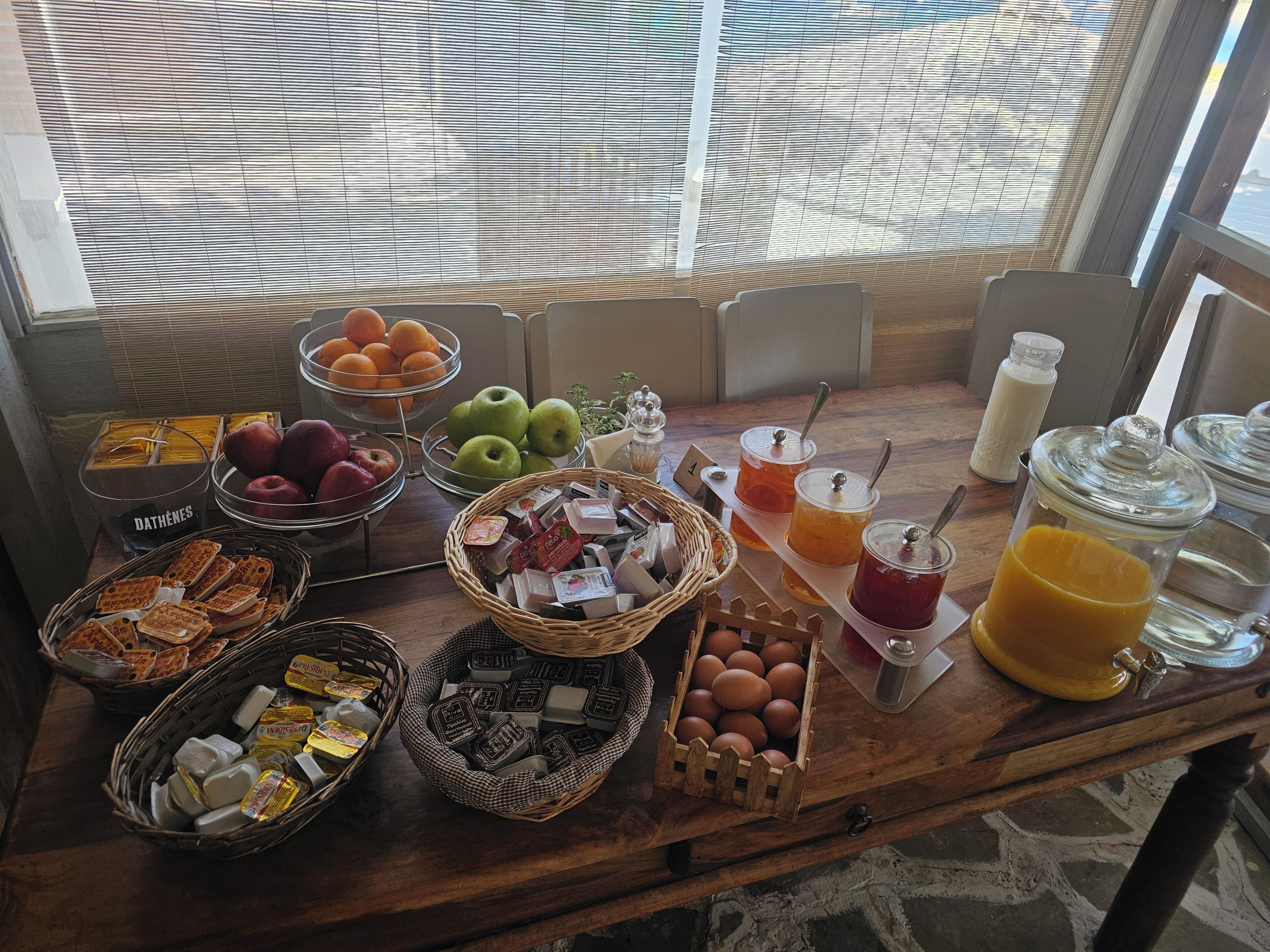 Een ontbijtbuffet met fruit, gebak en drankjes.
