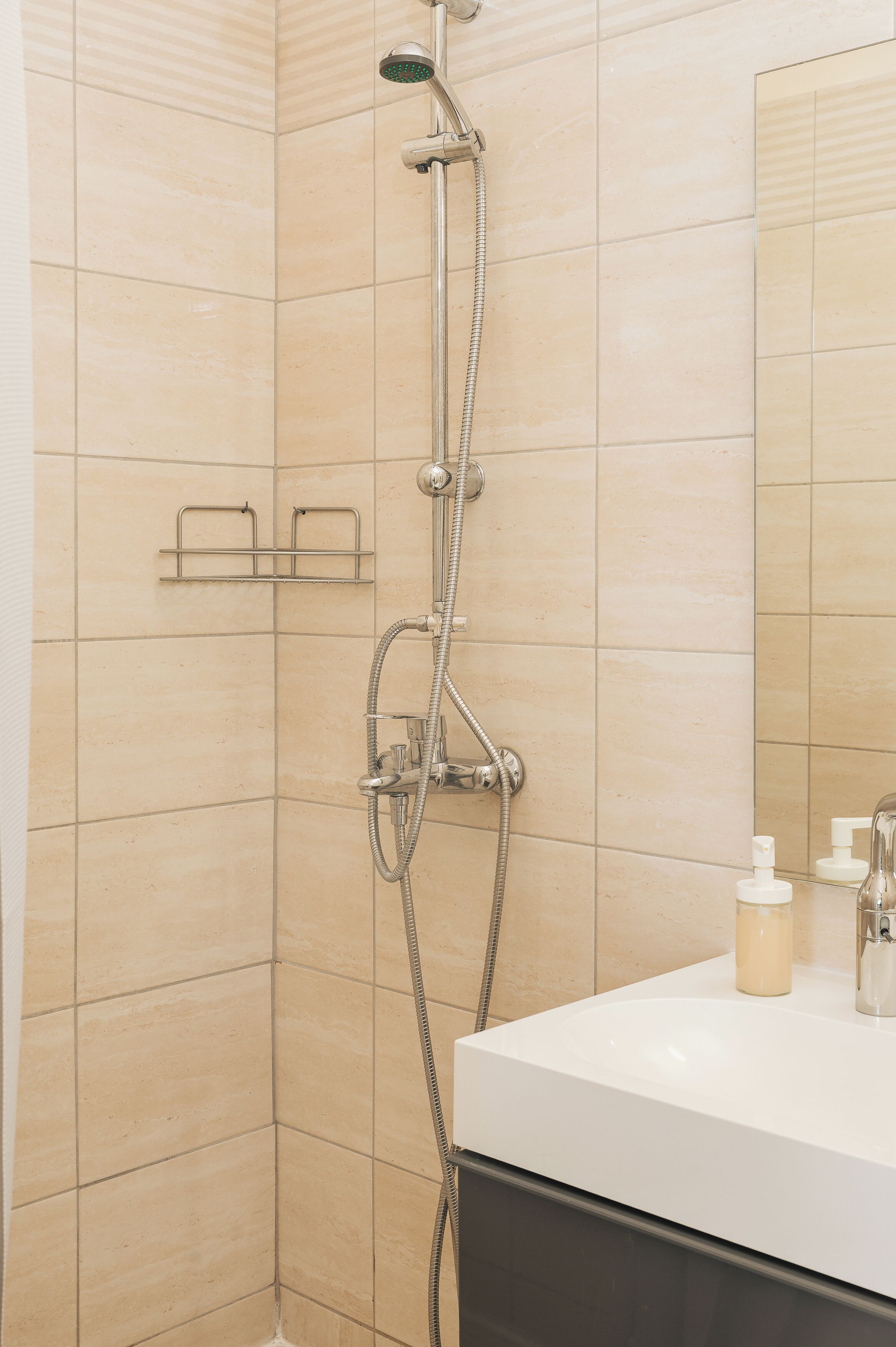 A bathroom with a shower, a sink, and a mirror.