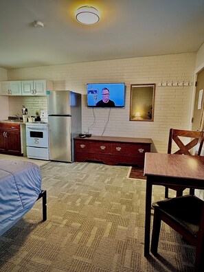 Habitación, 1 cama de matrimonio, cocina | Zona de estar | Televisión de pantalla plana de 50 pulgadas con canales por cable