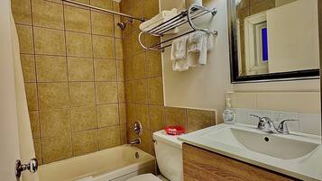 Une salle de bain avec une baignoire, des toilettes, un lavabo et un miroir.