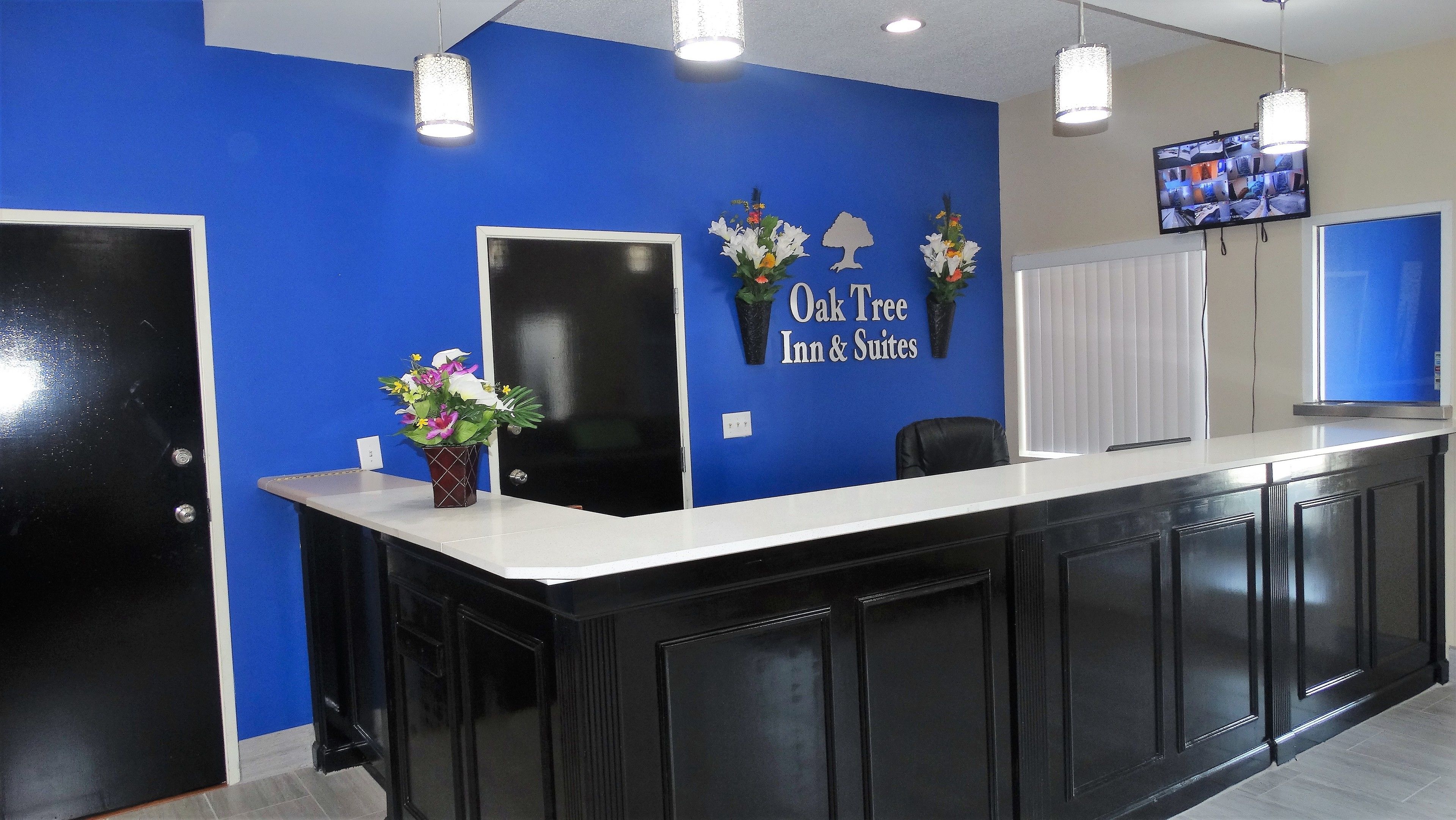 Una recepción con pared azul, puerta negra y pantalla de televisión.