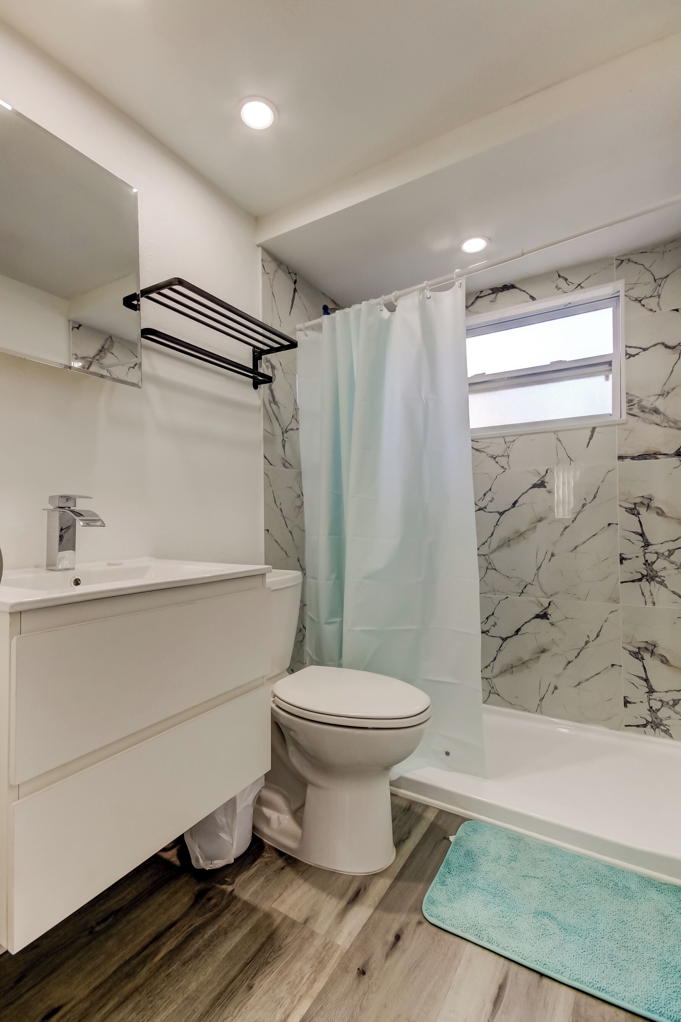 A bathroom with a white sink, toilet, and bathtub.