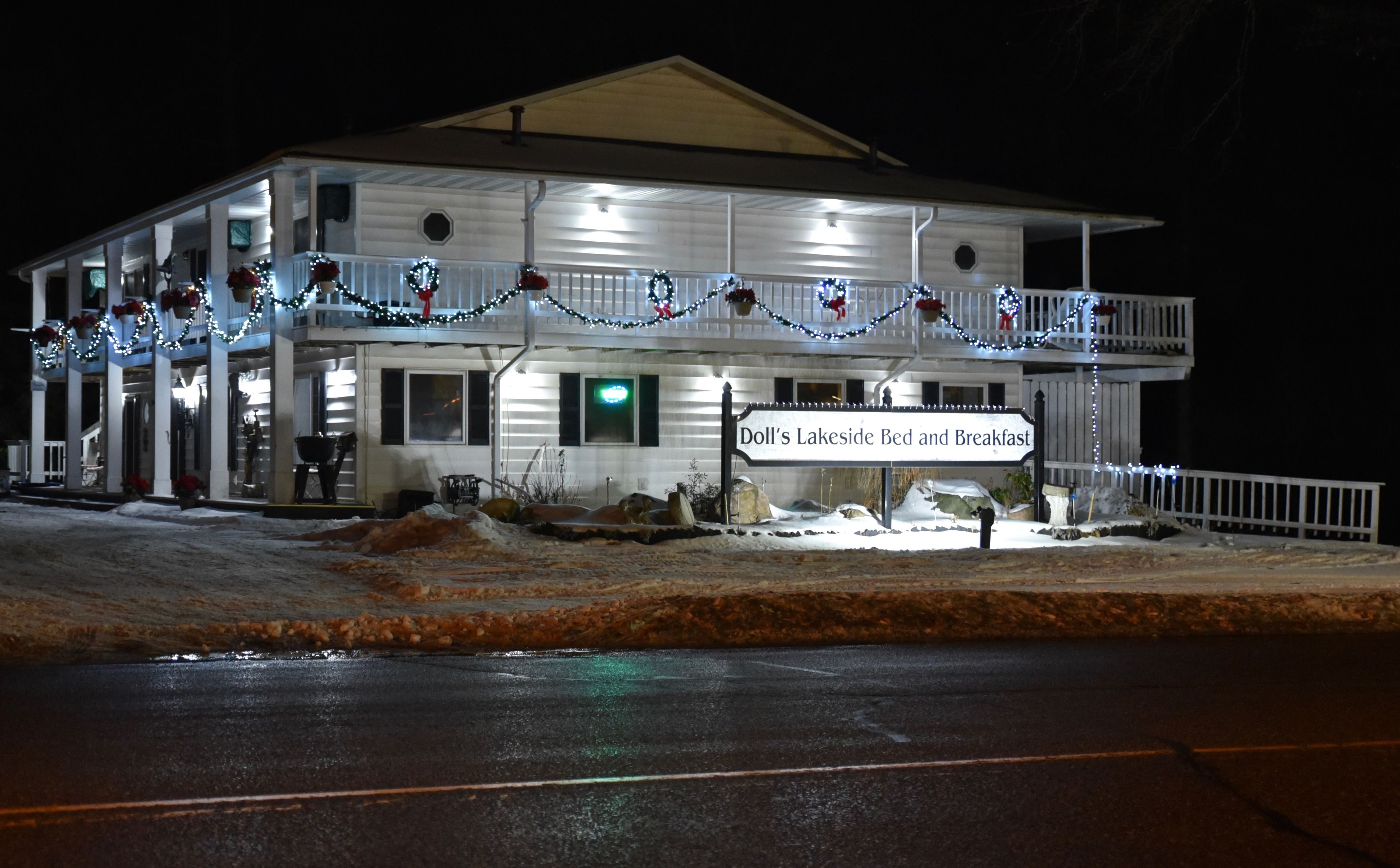 A two-story building with a sign reading "Doll's Lakeside Bed and Breakfast."