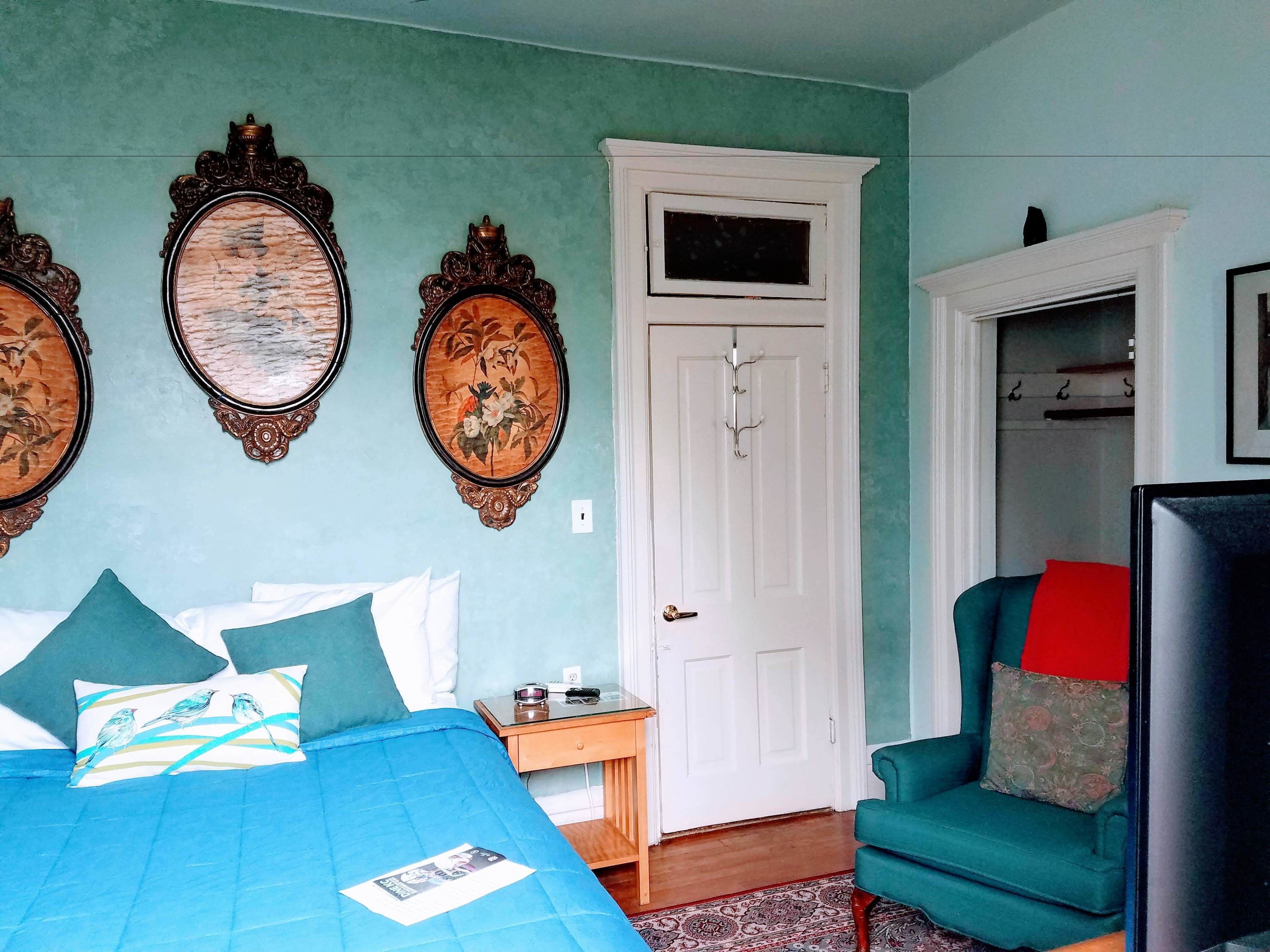 Een slaapkamer met een bed, een bureau, een stoel en een kledingkast.