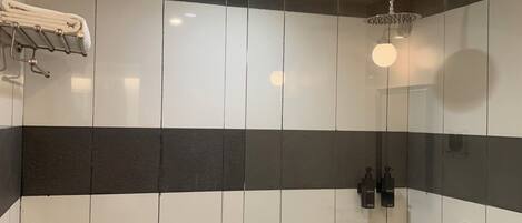 A modern bathroom with a glass shower enclosure, a towel rack, and a toilet.