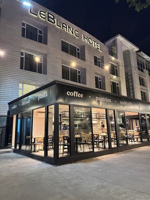A LEBLANC HOTEL with a coffee shop on the ground floor, featuring a glass facade and outdoor seating. - LeBlanc Hotel and Resort (Antipolo)