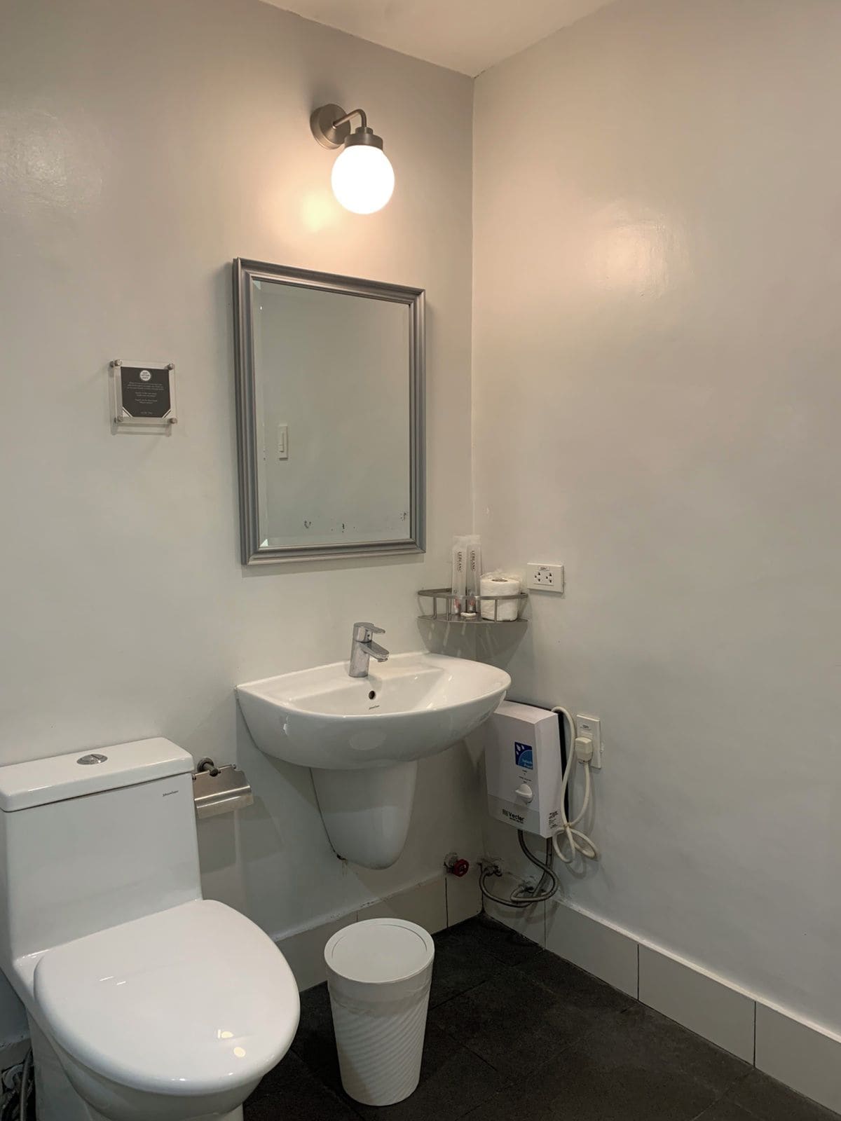 Un baño con inodoro, lavabo y espejo.