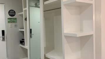 Una habitación con puerta corrediza de vidrio, paredes blancas y suelo de baldosas.