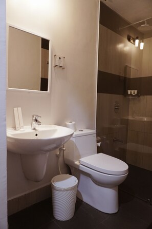 A modern bathroom with a white sink, toilet, and shower.