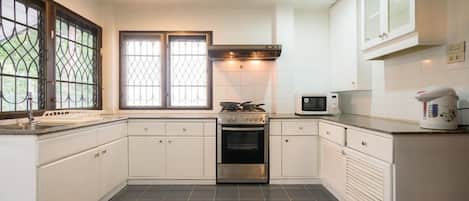 4-Bedroom House with Garden | Cocina privada | Frigorífico grande, microondas, horno y placa de cocina