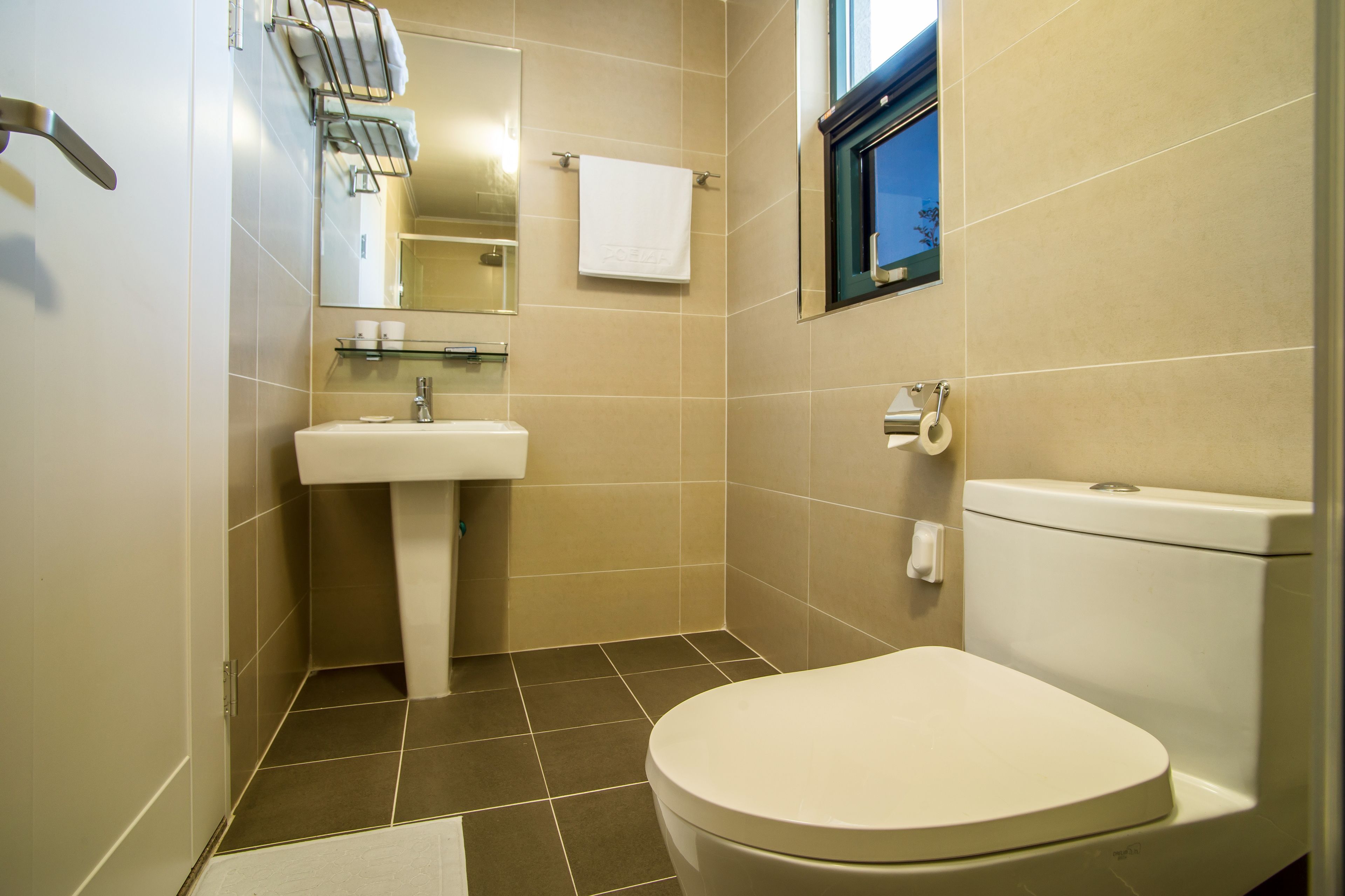 Un baño moderno con inodoro, lavabo y espejo.