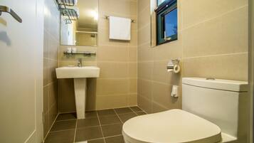 Un baño moderno con inodoro, lavabo y espejo.
