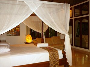 A room with a bed under a canopy, a night lamp, and a painting on the wall. - Bali Hidden Paradise Villa (Seminyak)