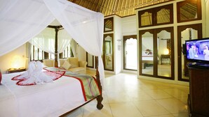 A hotel room with a bed, a television, and a large window. - Bali Hidden Paradise Villa (Seminyak)