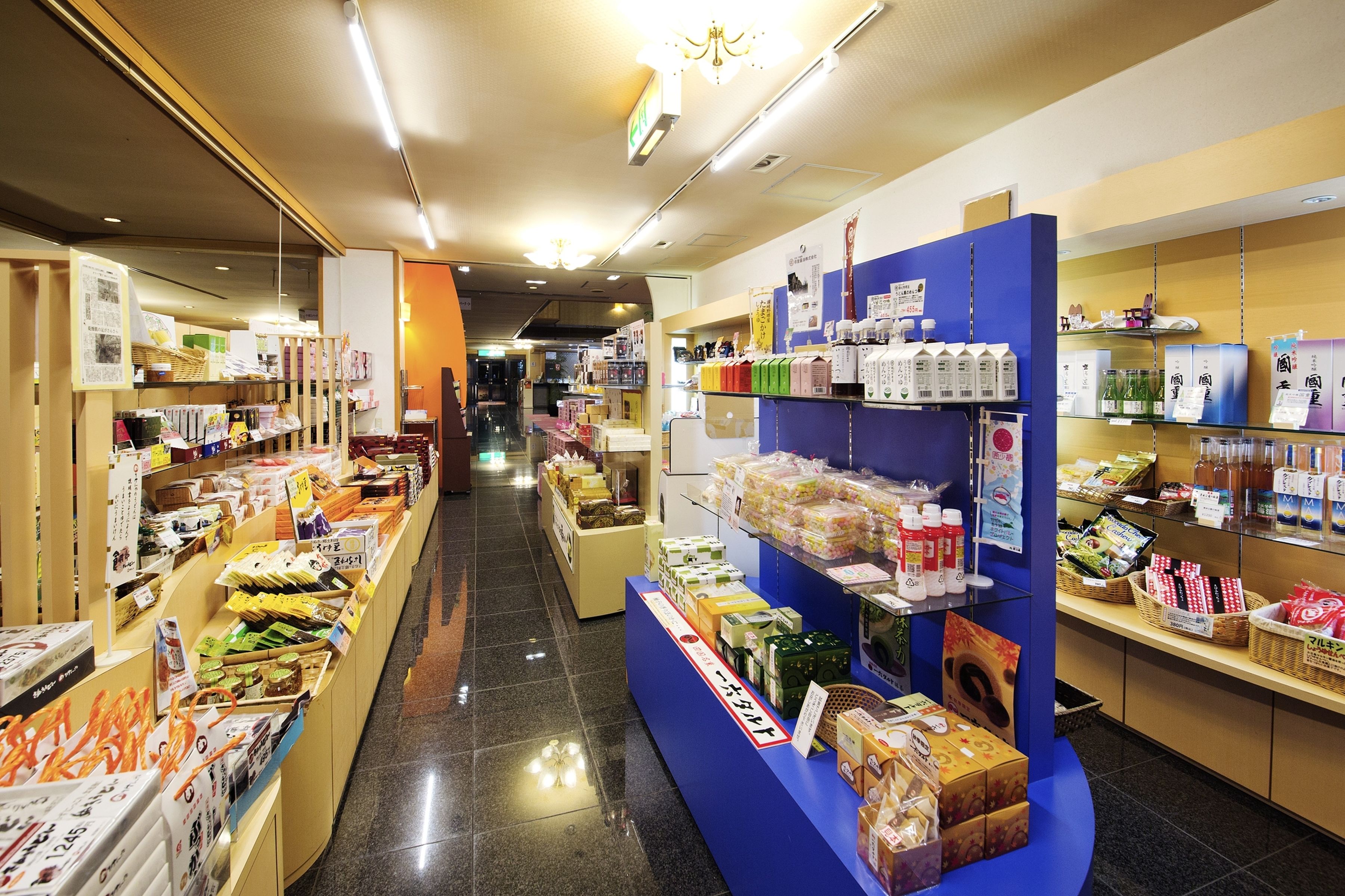 A well-lit store with shelves stocked with various packaged goods, including snacks and beverages.