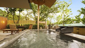 Un área de hidromasaje con bancos de madera y una pérgola.