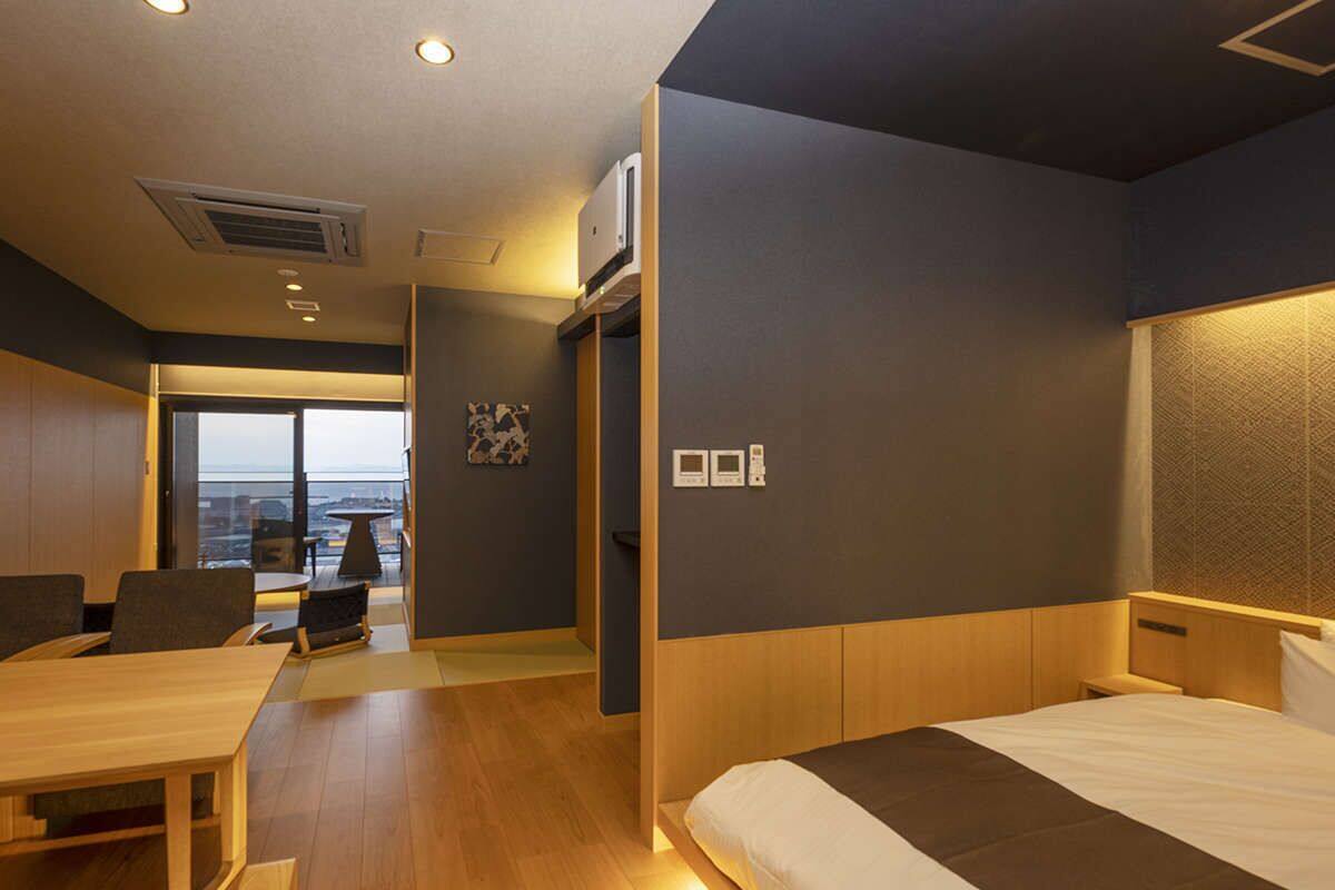 Una habitación de hotel moderna con una cama grande, un escritorio y vistas a la ciudad.