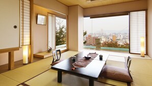 Una habitación japonesa tradicional con suelo de tatami, una mesa baja y puertas correderas.